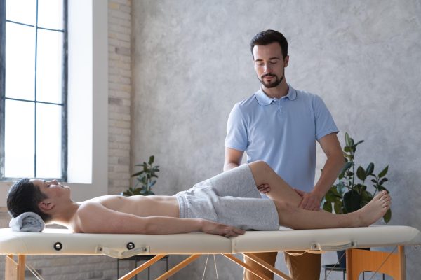 medium-shot-physiotherapist-checking-leg